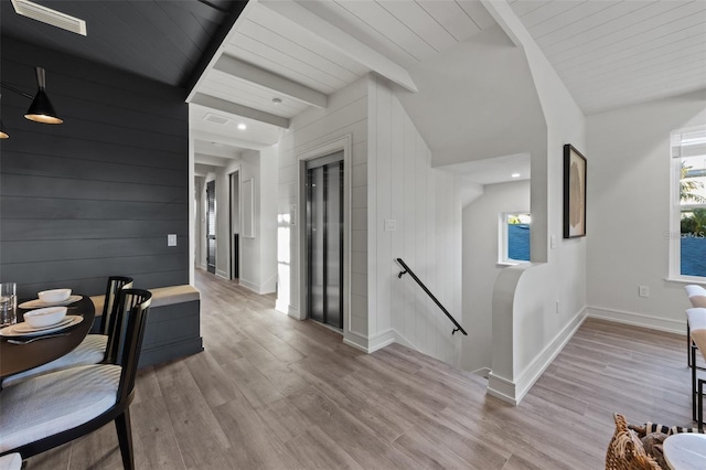 corridor featuring vaulted ceiling with beams, light hardwood / wood-style floors, and wooden ceiling