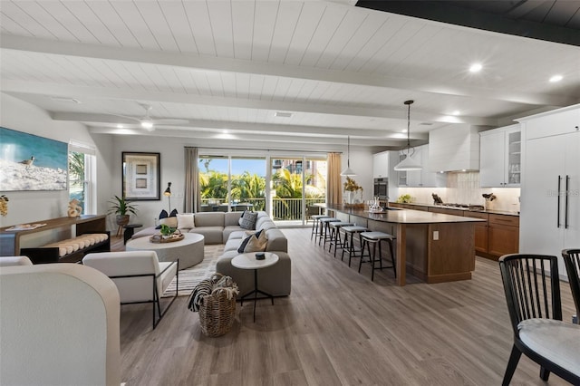 living room with beamed ceiling and hardwood / wood-style floors