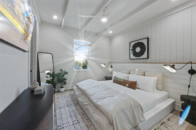 bedroom featuring beamed ceiling, wood walls, and hardwood / wood-style floors