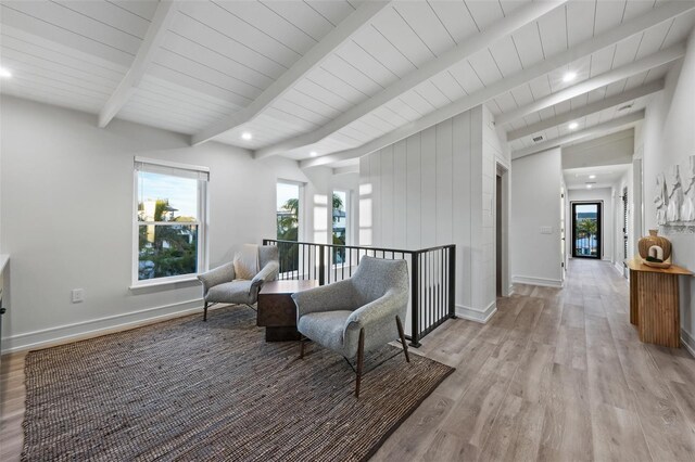 sitting room with vaulted ceiling with beams and light hardwood / wood-style floors