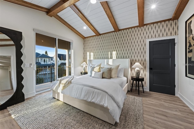 bedroom with access to exterior, vaulted ceiling with beams, and light hardwood / wood-style flooring