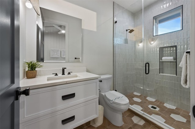 bathroom featuring toilet, vanity, tile patterned floors, and an enclosed shower