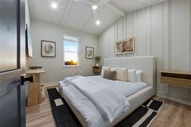 bedroom with vaulted ceiling with beams, wood ceiling, and light hardwood / wood-style flooring