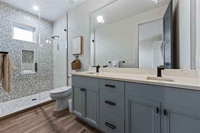 bathroom featuring vanity, hardwood / wood-style flooring, toilet, and an enclosed shower