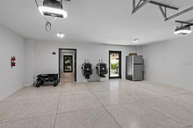 garage featuring stainless steel fridge and a garage door opener