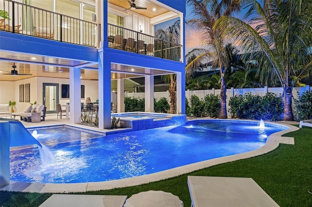 view of swimming pool featuring pool water feature, ceiling fan, an outdoor living space, and an in ground hot tub