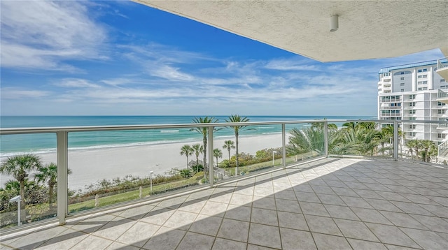 balcony featuring a beach view and a water view