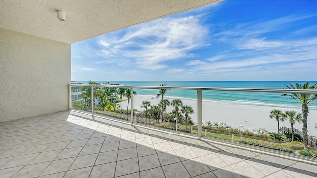 balcony featuring a view of the beach and a water view