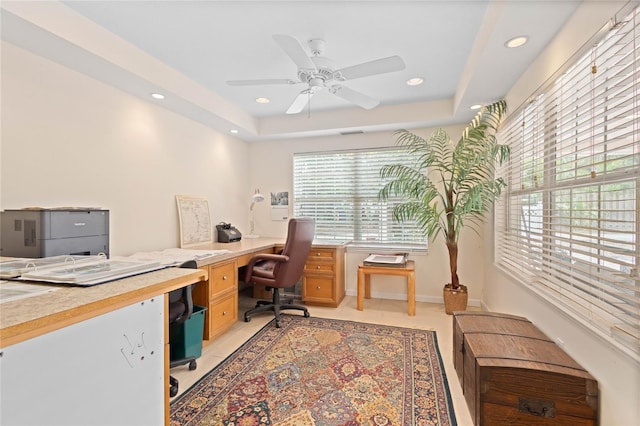 tiled home office featuring ceiling fan and a raised ceiling