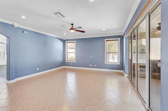 tiled empty room with ceiling fan, a textured ceiling, and ornamental molding