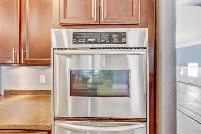 room details featuring stainless steel double oven and crown molding