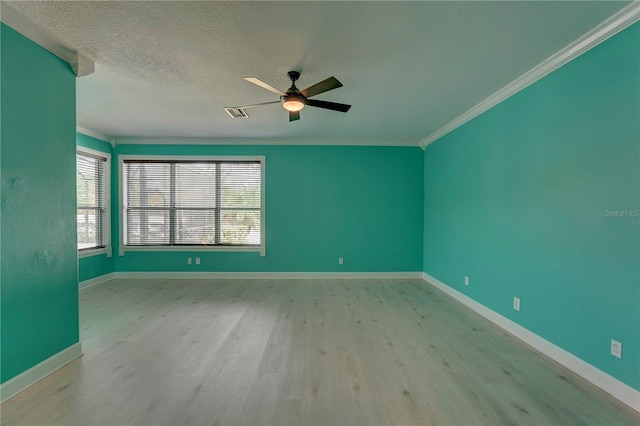 empty room with ceiling fan, light wood-type flooring, a textured ceiling, and ornamental molding