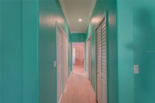 hallway featuring ornamental molding and light hardwood / wood-style flooring