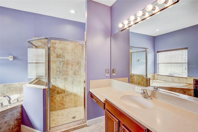 bathroom featuring plus walk in shower, vanity, and tile patterned floors