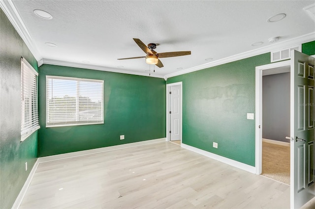 unfurnished bedroom featuring ceiling fan, light wood-type flooring, a textured ceiling, and ornamental molding