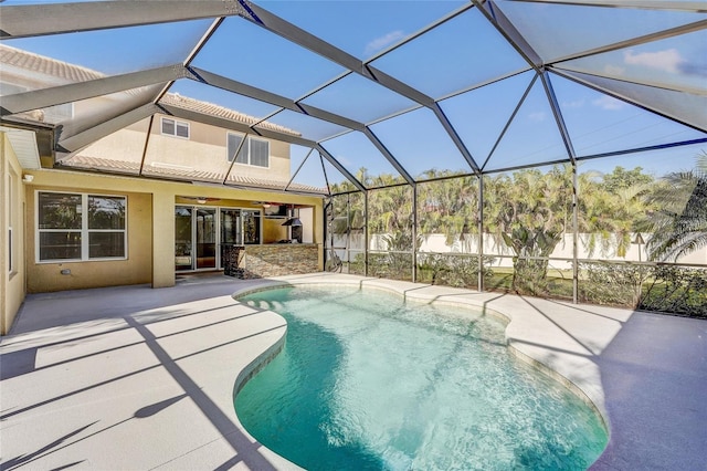 view of pool with ceiling fan, a patio area, and glass enclosure