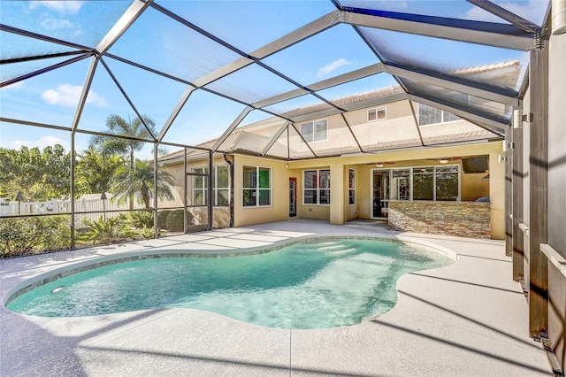 view of swimming pool featuring a patio, glass enclosure, and ceiling fan