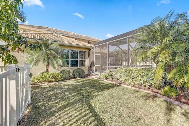 back of house featuring a lawn and a lanai