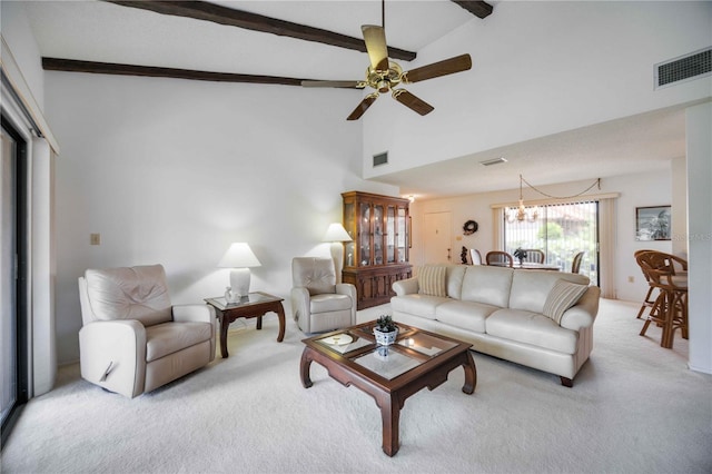 carpeted living room with high vaulted ceiling, ceiling fan with notable chandelier, and beam ceiling