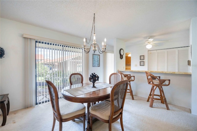 dining area with ceiling fan, light carpet, and a textured ceiling