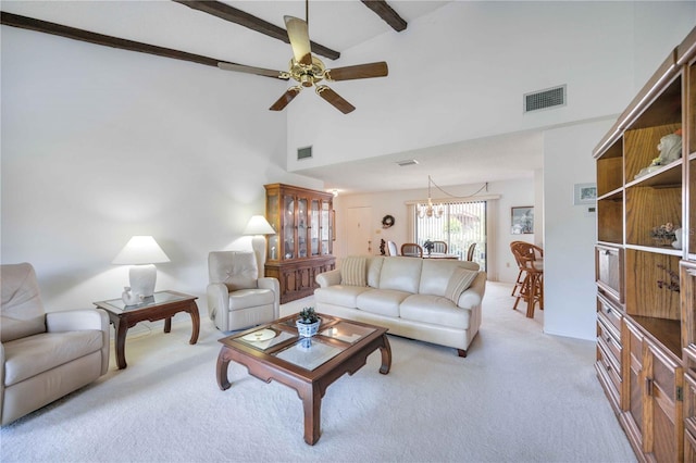 living room featuring beam ceiling, ceiling fan with notable chandelier, light colored carpet, and a high ceiling