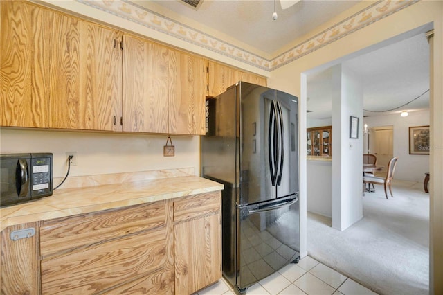 kitchen featuring light carpet, black appliances, and a textured ceiling