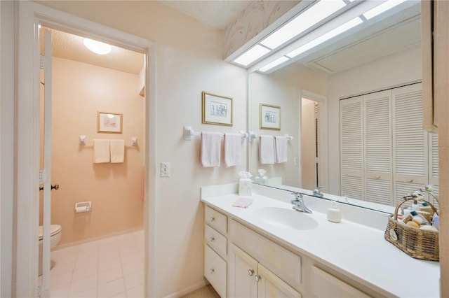 bathroom featuring vanity, a textured ceiling, and toilet