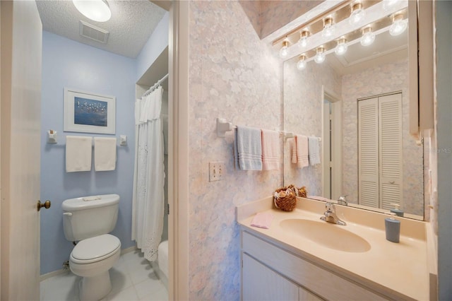 bathroom featuring vanity, toilet, tile patterned flooring, and a textured ceiling