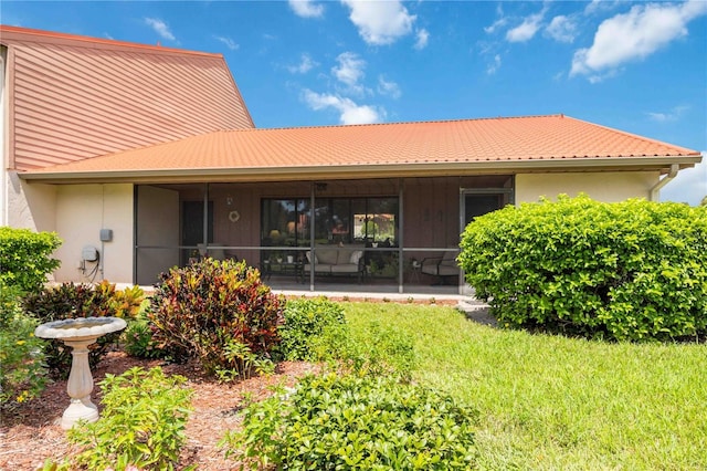 back of property with a sunroom