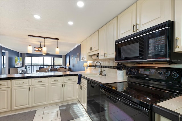 kitchen with kitchen peninsula, sink, black appliances, light tile patterned floors, and tile counters