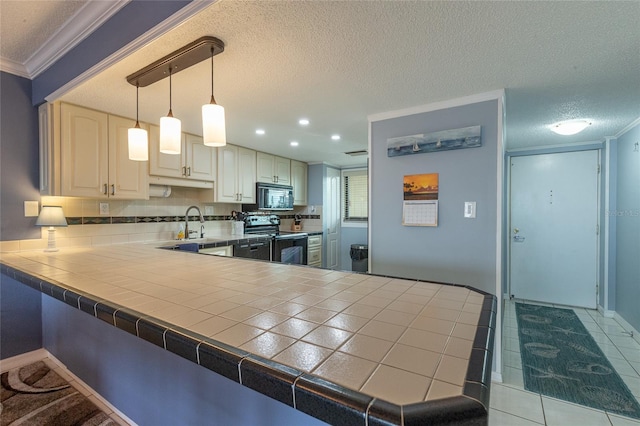 kitchen with tile countertops, decorative backsplash, hanging light fixtures, and black appliances