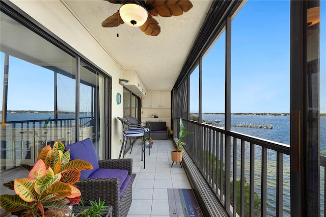 sunroom featuring a water view, plenty of natural light, and ceiling fan