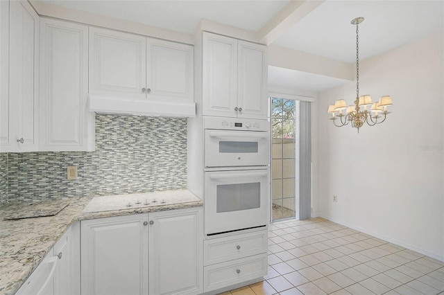 kitchen with white cabinetry, white double oven, hanging light fixtures, an inviting chandelier, and tasteful backsplash