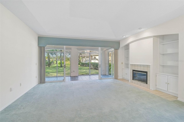 unfurnished living room featuring a fireplace, built in features, and light colored carpet