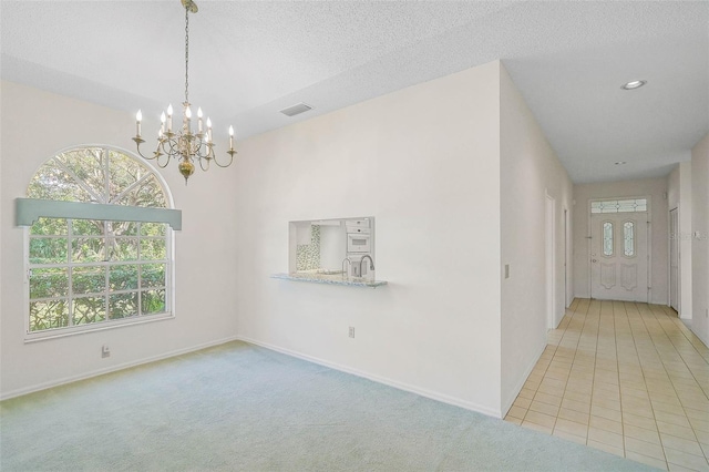 interior space featuring a chandelier and a textured ceiling