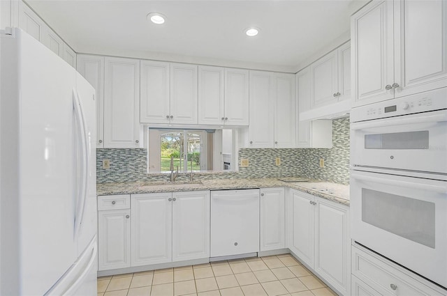 kitchen featuring white cabinetry, light tile patterned flooring, white appliances, and sink