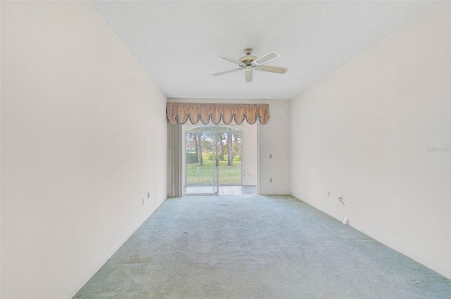 carpeted empty room featuring ceiling fan and a textured ceiling