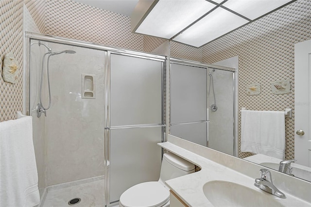 bathroom featuring vanity, an enclosed shower, and toilet