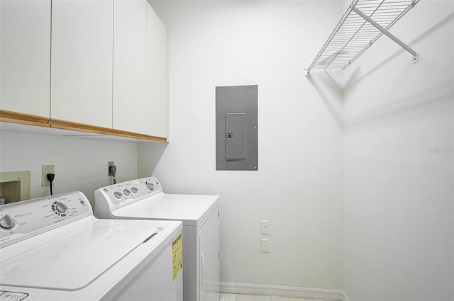 washroom with cabinets, washing machine and dryer, and electric panel