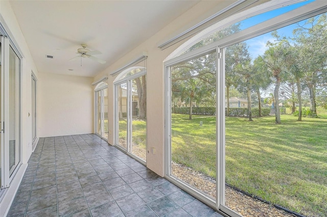 unfurnished sunroom featuring ceiling fan