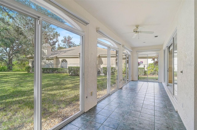 unfurnished sunroom featuring plenty of natural light and ceiling fan