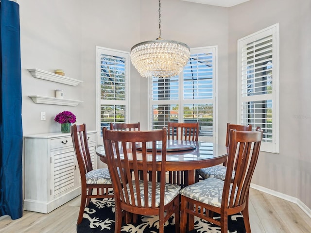 dining space with a chandelier and light wood-type flooring