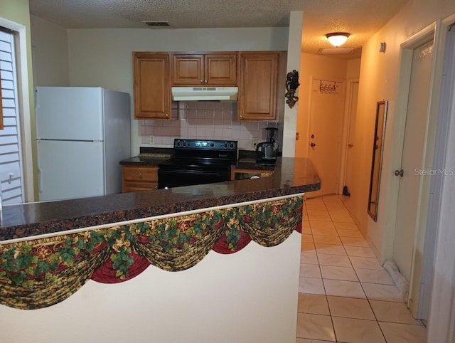 kitchen with tasteful backsplash, a textured ceiling, electric range, white fridge, and light tile patterned flooring