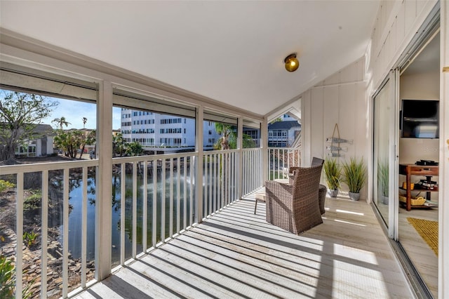 sunroom / solarium with a water view and lofted ceiling