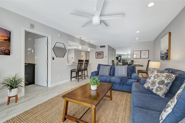 living room featuring ceiling fan and light wood-type flooring