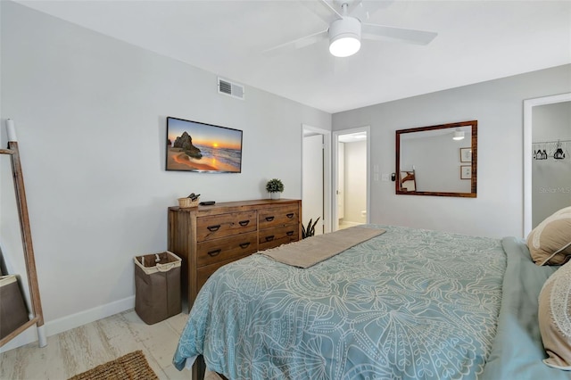 bedroom with ensuite bath, ceiling fan, and light wood-type flooring