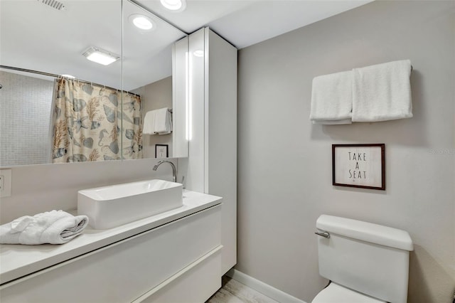 bathroom with a shower with curtain, toilet, and vanity