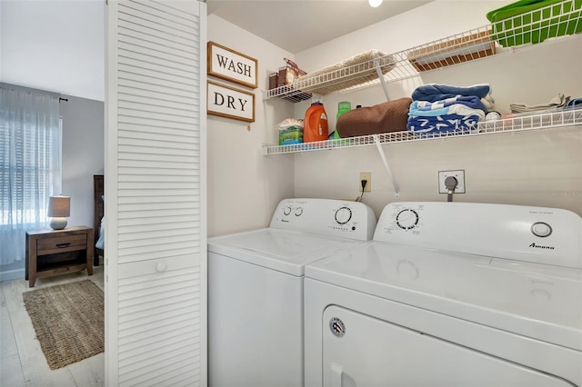 washroom with independent washer and dryer and light hardwood / wood-style flooring