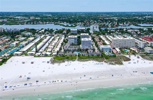 birds eye view of property with a water view and a beach view