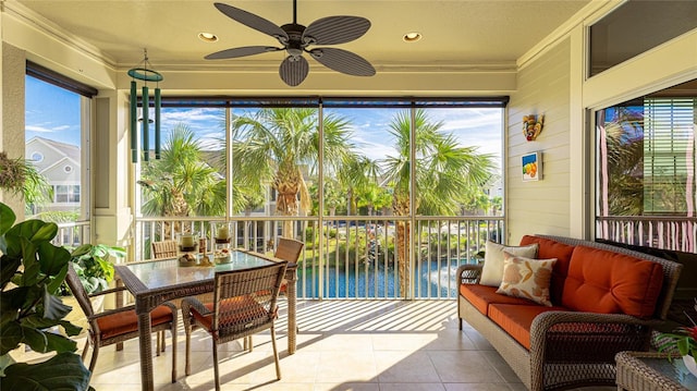 sunroom with ceiling fan, a wealth of natural light, and a water view